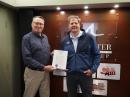 New Hampshire Governor Chris Sununu holds a proclamation declaring June as Amateur Radio Month with Section Manager of the ARRL New Hampshire Section Pete Stohrer, W1FEA. [Barron Clogston, photo.]